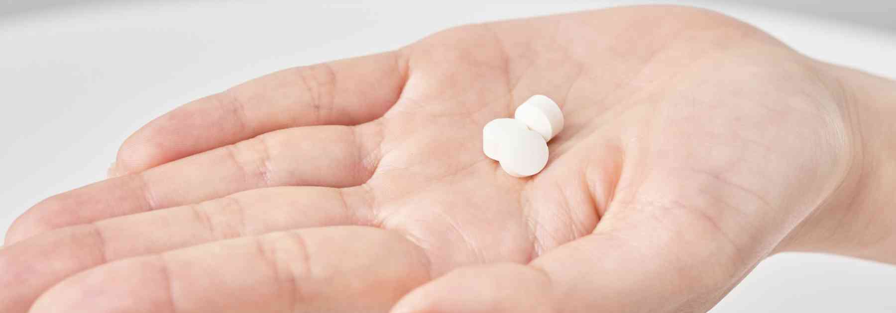 person holding white tablets