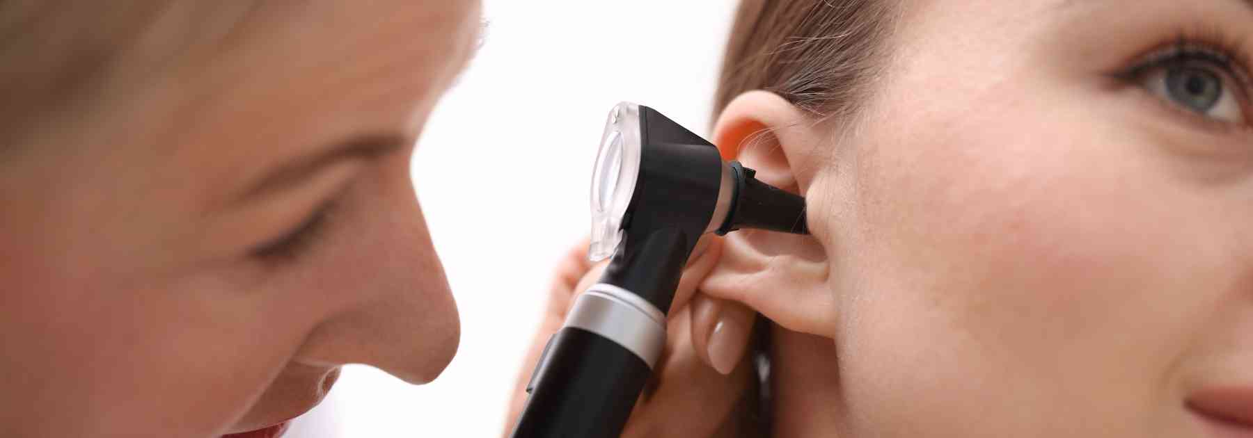 doctor looking in ear of female patient