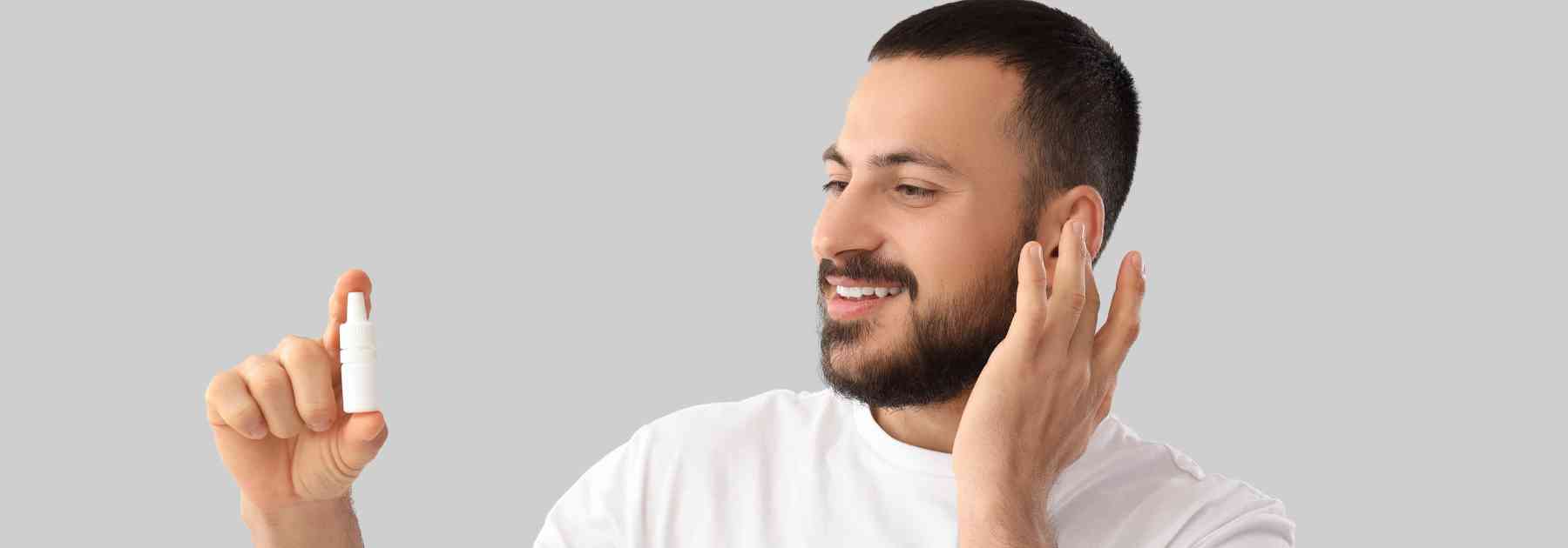 man holding bottle of ear drops