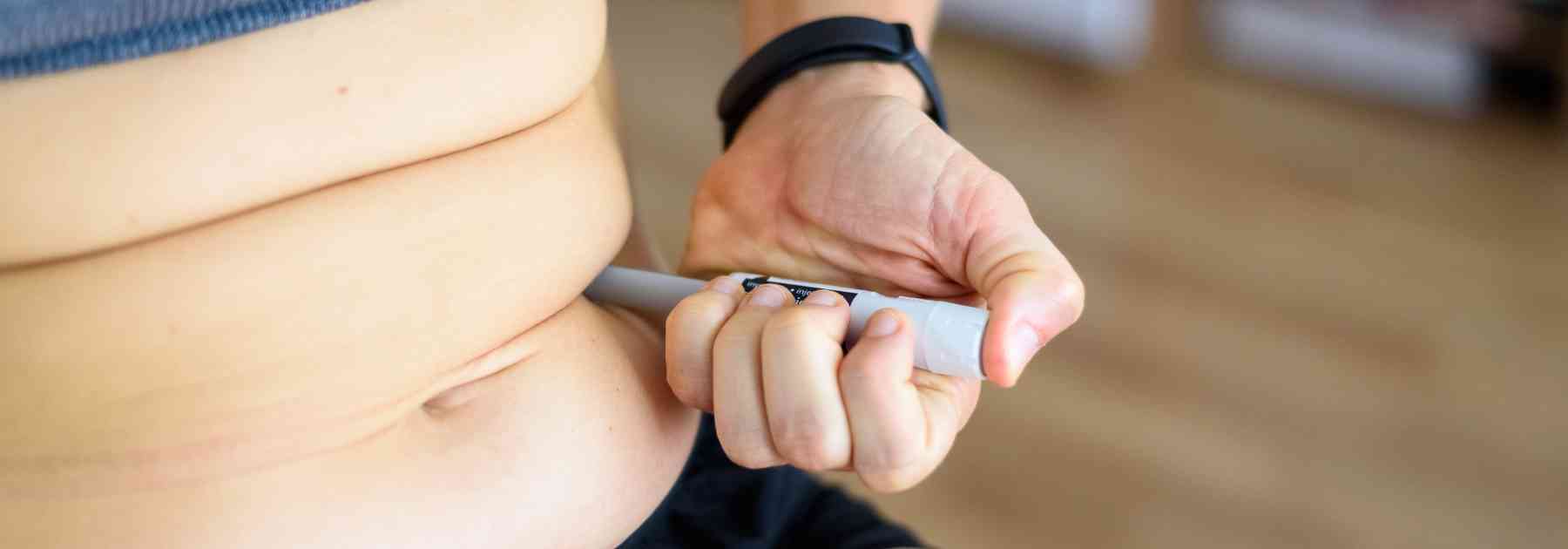 person injecting weight loss injection into their stomach