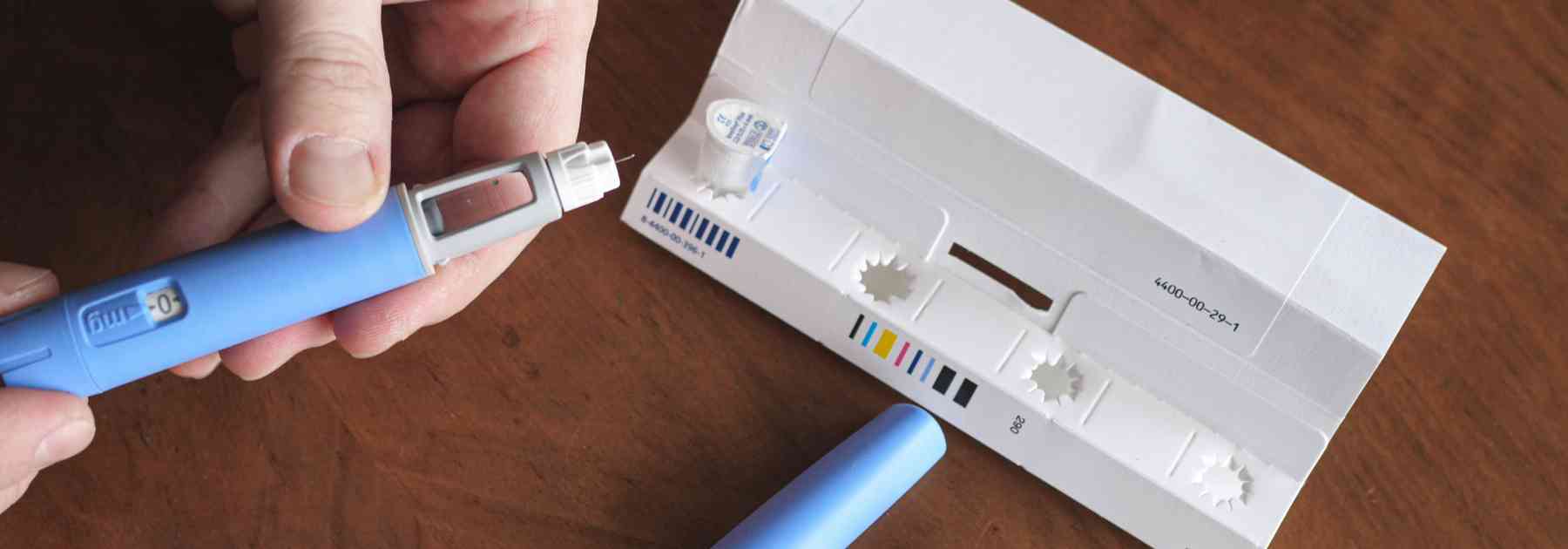 person taking weight loss injection out of packaging