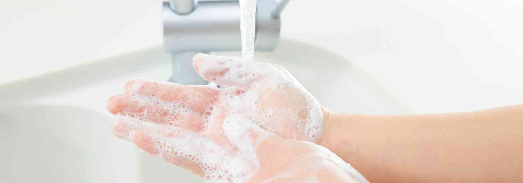person washing their hands with soap