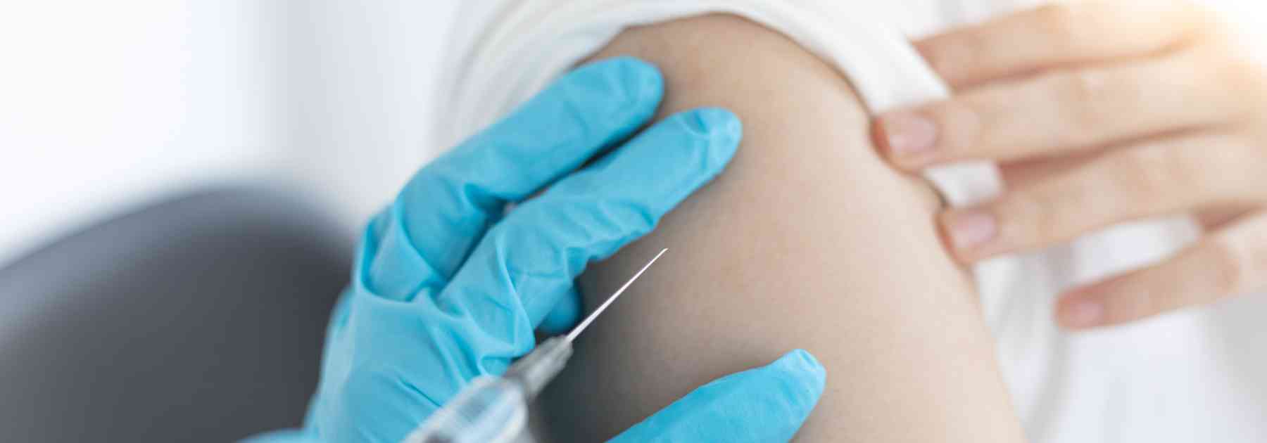 patient in white shirt receiving vaccine in arm