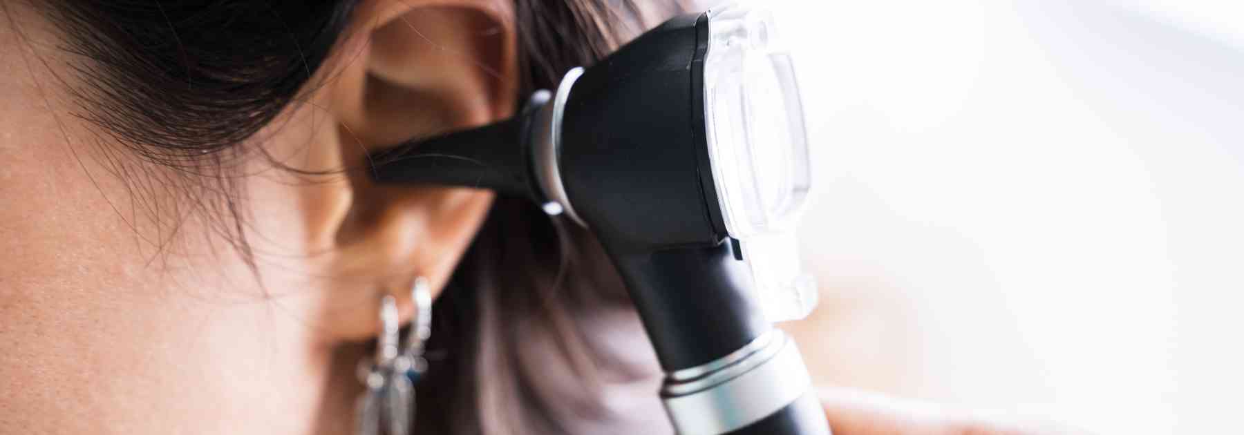 doctor looking in female patient's ear