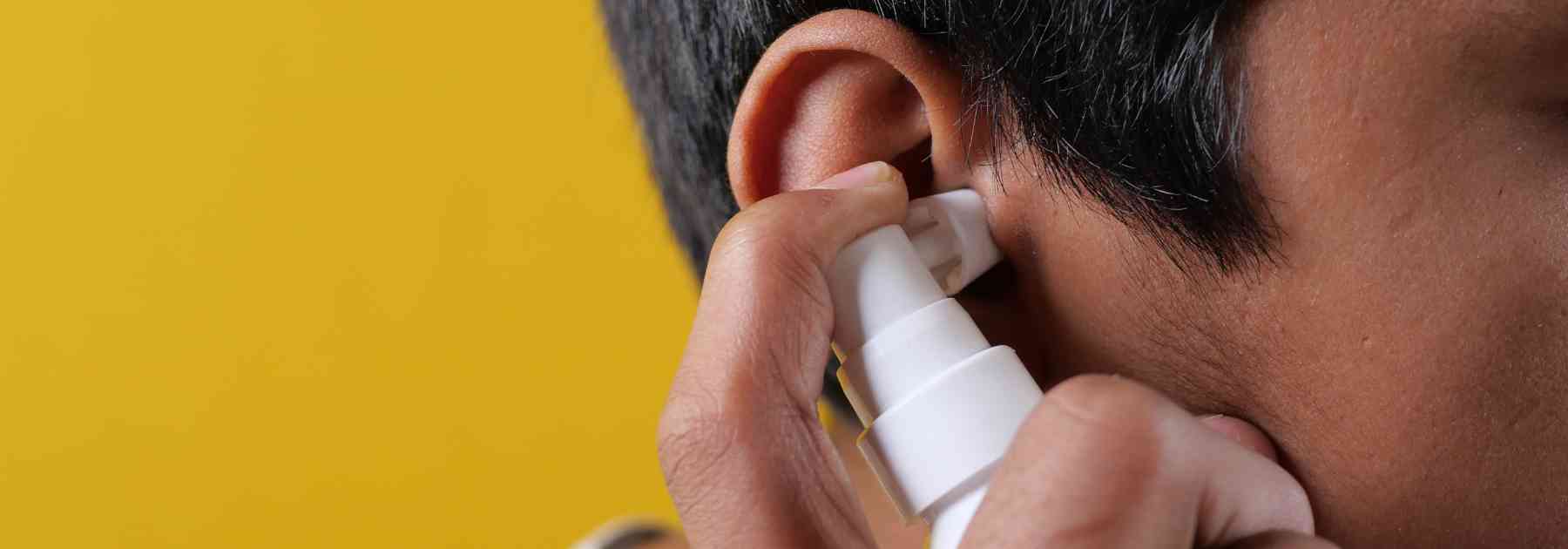 man using earwax removal spray