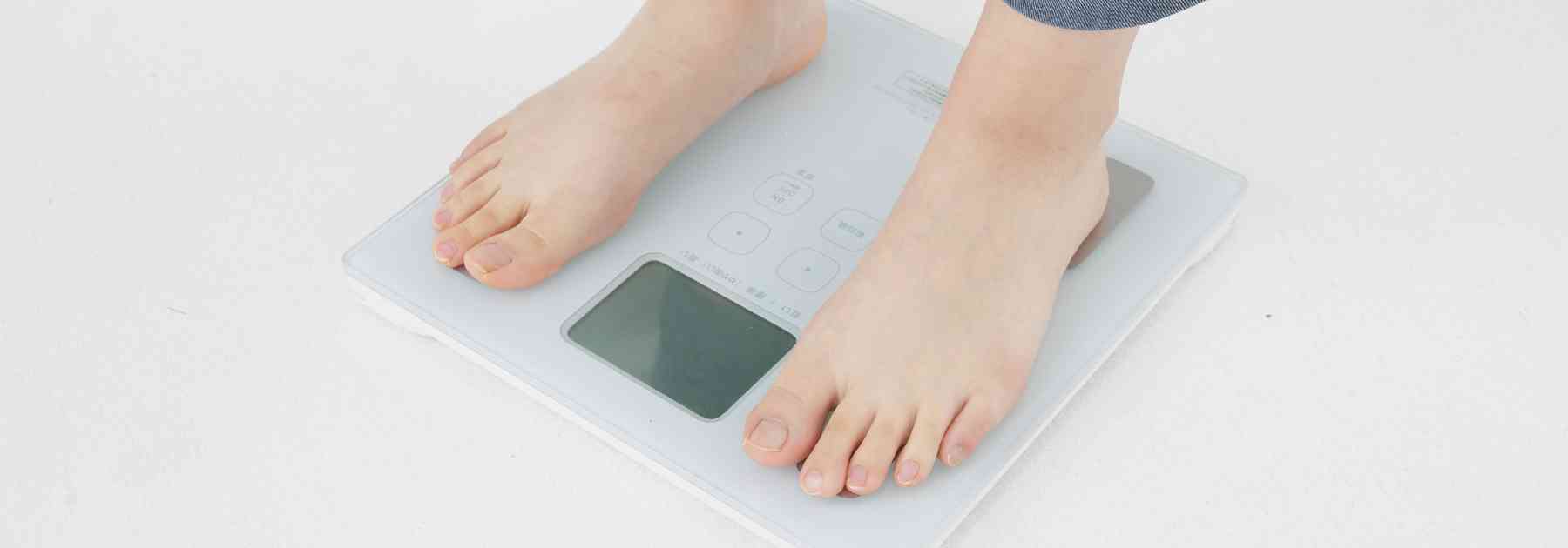 person in bare feet standing on scales