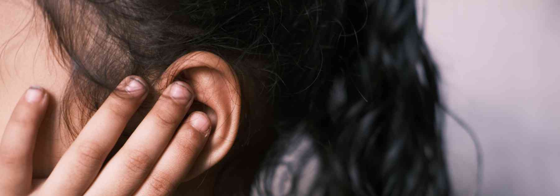 young woman holding her ear