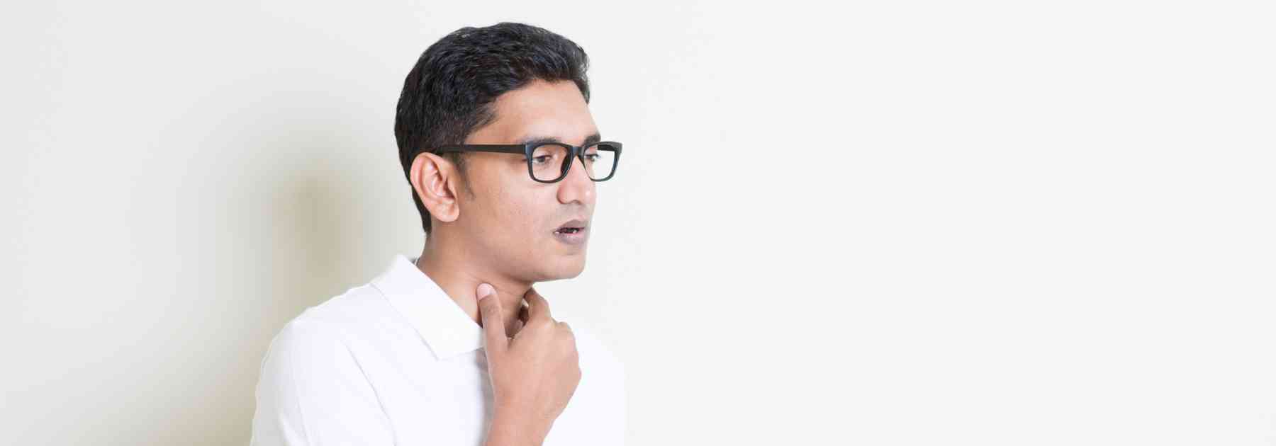 man clutching throat in discomfort