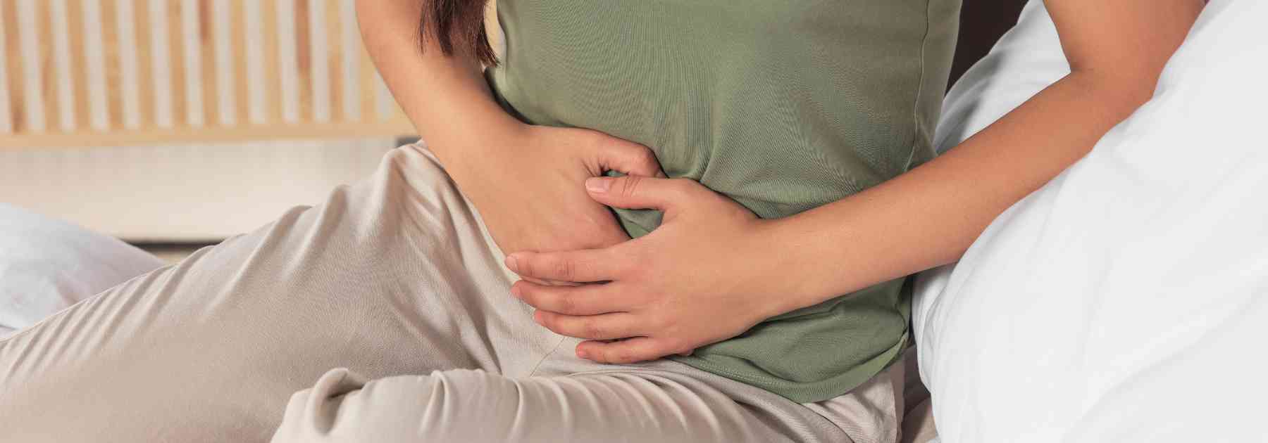 woman in green shirt clutching lower area