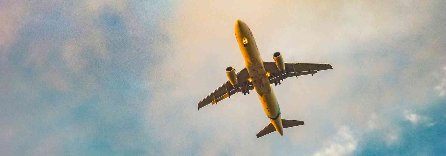 underside view of plane in blue sky