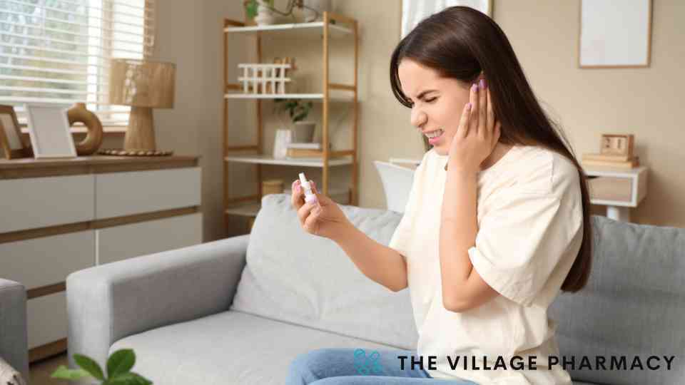 young woman closing her eyes using ear drops