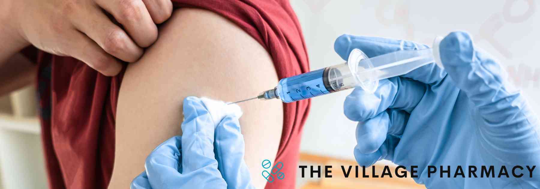 person in red shirt receiving vaccine in arm